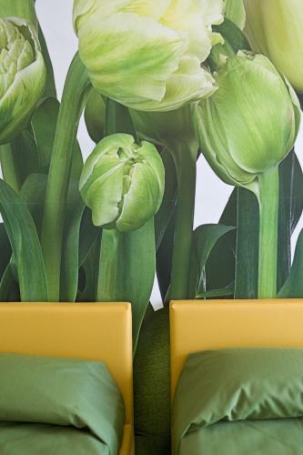 two yellow vases with white flowers on a wall at Hotel Acquadolce in Peschiera del Garda