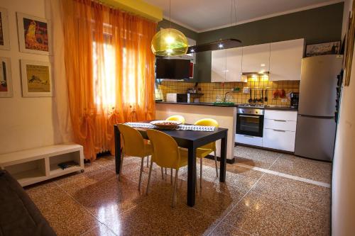 cocina con mesa negra y sillas amarillas en Happy Home BO Fiera Self Check-in en Bolonia