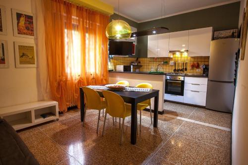 a kitchen with a black table and yellow chairs at Happy Home BO Fiera Self Check-in in Bologna