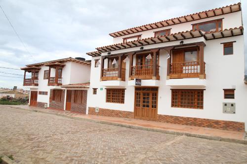 un edificio con puertas de madera y una calle adoquinada en Hotel Villasaurio, en Sáchica