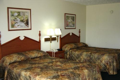 a hotel room with two beds and a phone at Homegate Inn in Louisville