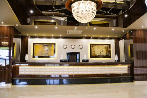 a hotel lobby with a reception desk and a chandelier at Hotel Cartoon Razgrad in Razgrad