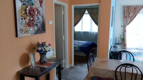 a dining room with a table and a room with a bed at Relaxing Retreats at Cocobay Apartments in Port Dickson