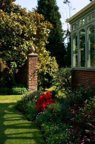 a garden with flowers and a house with a window at Flackley Ash Country House Hotel in Rye