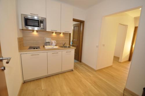 a kitchen with a sink and a microwave at Hotel Garni Wurzer in Velden am Wörthersee