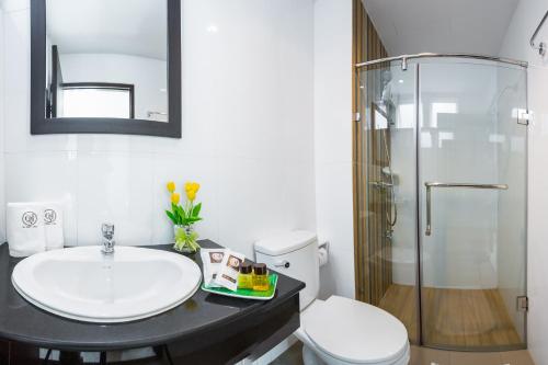 a bathroom with a sink and a shower and a toilet at U Hatyai Hotel in Hat Yai