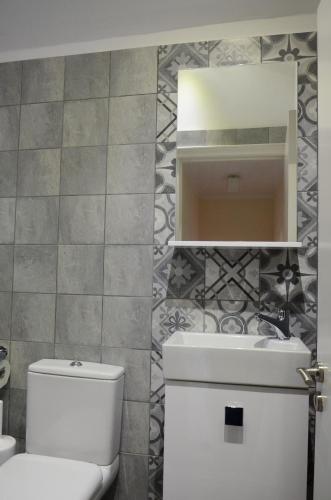 La salle de bains est pourvue de toilettes blanches et d'un lavabo. dans l'établissement Jenny's Apartment, à Gaios
