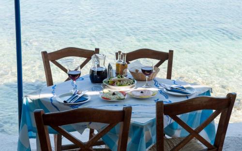 a table with a blue table cloth and wine glasses at La Grotta in Volimes