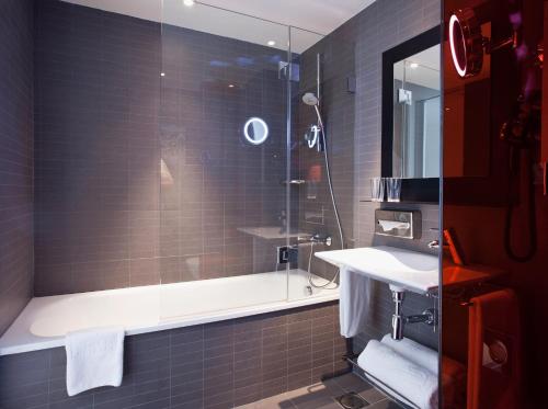 a bathroom with a shower and a sink and a tub at Vincci Bit in Barcelona