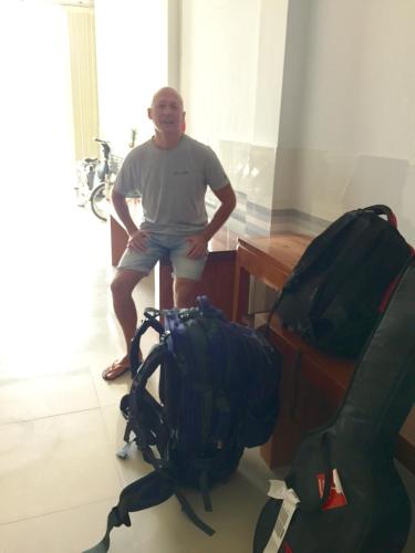 a man sitting next to a desk with his backpack at Gia Loi Hotel in Da Nang