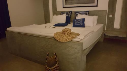 a bed with a hat sitting on top of it at Nagenahira Beach Villa in Nilaveli