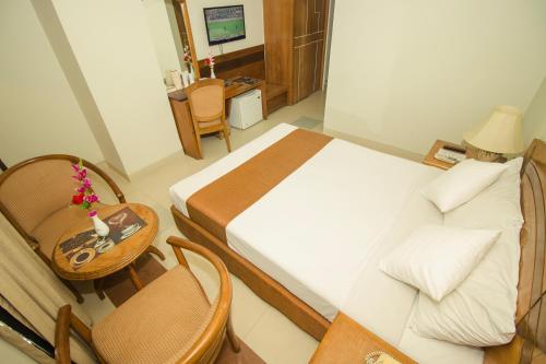 a bedroom with a bed and a table and chairs at Hotel Victory - Best in City Center in Dhaka