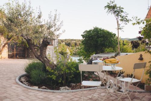 a patio with a table and chairs and a tree at The Residence in Šibenik