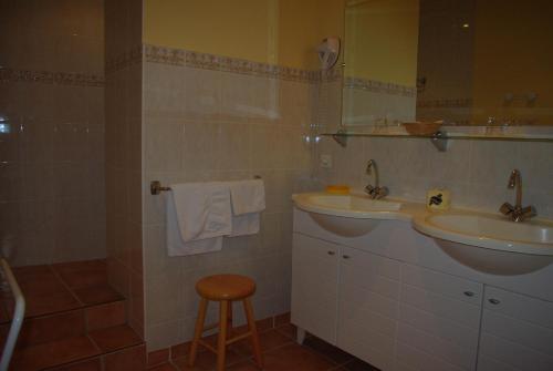 a bathroom with two sinks and a stool at Le Mas de l'Amandier in Saint-Saturnin-lès-Avignon