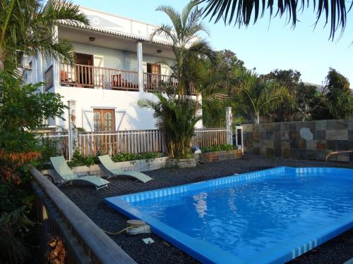 a swimming pool in front of a house at Le Bleuet in Saint-Leu