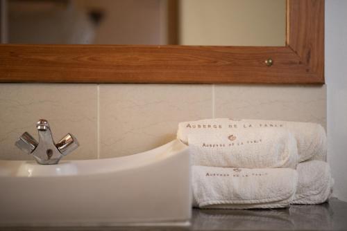 a bathroom sink with towels on top of it at Auberge de la Table in Toliara