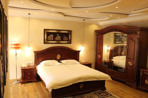 a bedroom with a large bed and a large mirror at Atlas B&B Hotel in Dushanbe