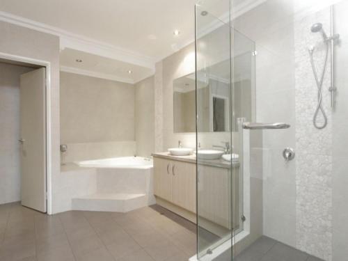 a bathroom with a shower and a sink and a tub at Huge House on the Grand Canal in Mandurah