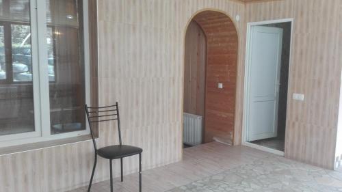 a black chair sitting in front of a building at Guest House Sabauri in Stepantsminda