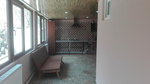 a hallway with a bench in a room with windows at Guest House Sabauri in Stepantsminda