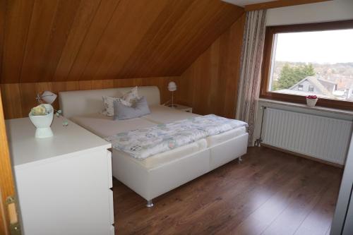 ein kleines Schlafzimmer mit einem Bett und einem Fenster in der Unterkunft Ferienwohnung Hoher Weg in Clausthal-Zellerfeld