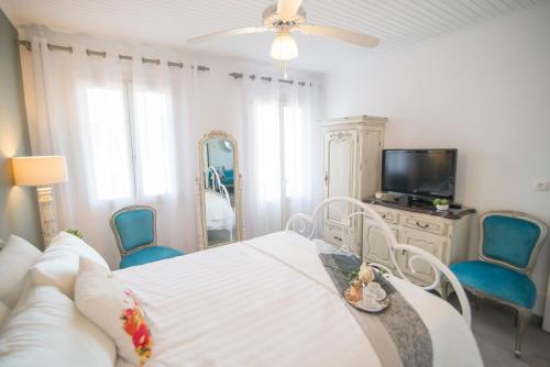 a bedroom with a bed and a tv and blue chairs at Bay View House in Vathi