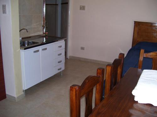 cocina con fregadero, mesa y sillas en Hotel Avenida, en La Rioja