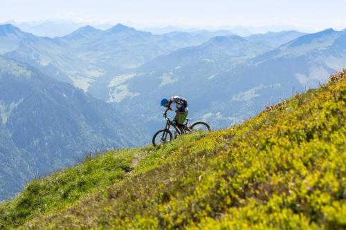 a person riding a bike on a hill at Hotel Gretina in Bezau