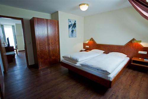 a bedroom with a large bed with a wooden headboard at Hotel Ritter in Bruchsal