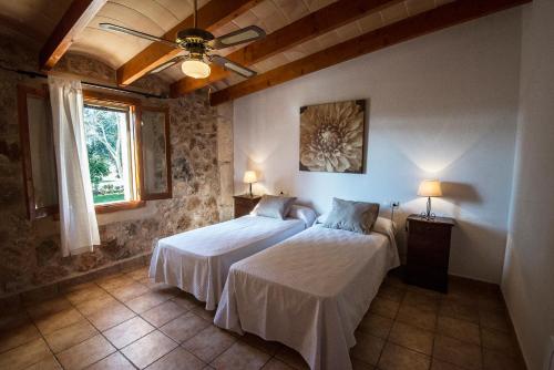 a bedroom with two beds and a ceiling fan at Agroturisme Son Llado in Campos