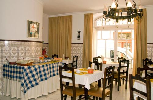 a kitchen with tables and chairs and a dining room at Hotel Leiriense in Leiria