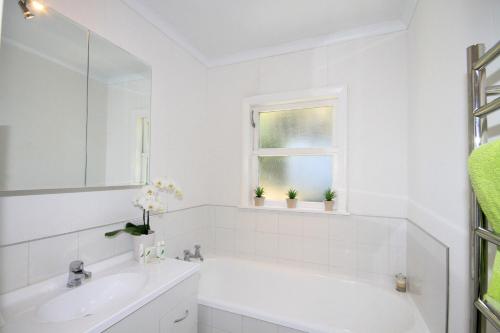 uma casa de banho branca com uma banheira e um lavatório em Durie Vale Retreat em Whanganui