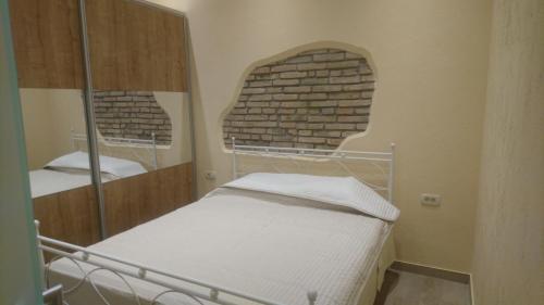 Cette petite chambre comprend un lit et un mur en briques. dans l'établissement Apartments Opatija-Ičići, à Ičići