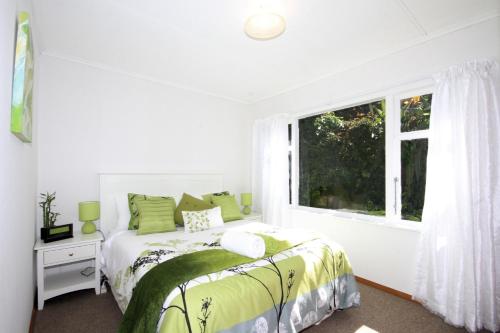 a white bedroom with a bed and a window at Durie Vale Retreat in Whanganui