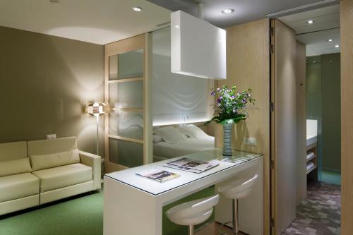 a hotel room with a bed and a table with flowers at Ako Suites Hotel in Barcelona