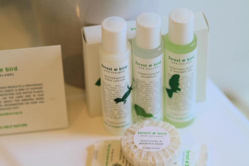 three bottles of moisturizers are sitting on a table at Durie Vale Retreat in Whanganui
