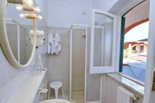 a bathroom with a toilet and a mirror at Hotel Costa d'Oro in Santa Maria di Castellabate