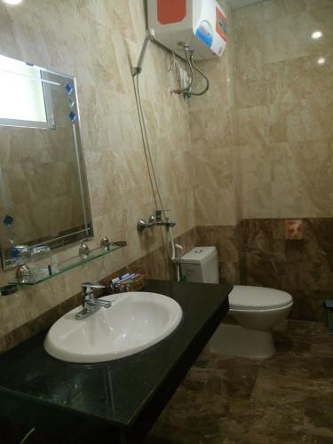 a bathroom with a sink and a toilet and a mirror at Hoang Ngoc Hotel in Dồng Văn
