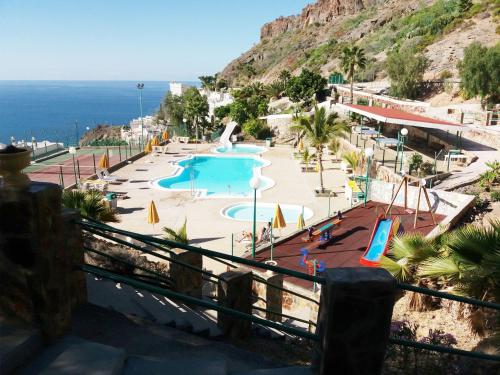 a resort with a swimming pool and the ocean at Apartamento Alegria in Playa del Cura
