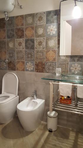 La salle de bains est pourvue de toilettes blanches et d'un lavabo. dans l'établissement La Tana Cerdomare, à Poggio Moiano