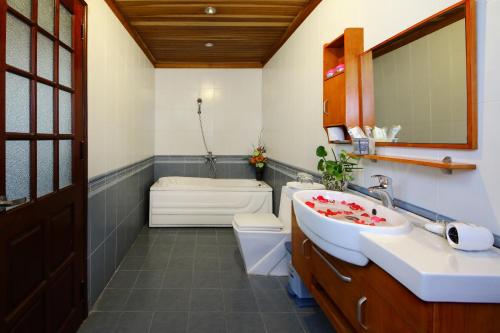 y baño con lavabo, aseo y bañera. en Hoa Mau Don Homestay, en Hoi An