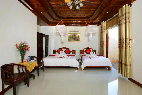 1 dormitorio con 2 camas y techo en Hoa Mau Don Homestay, en Hoi An
