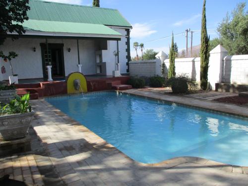 a swimming pool in front of a house at Van Rhyn Guest House in Vanrhynsdorp