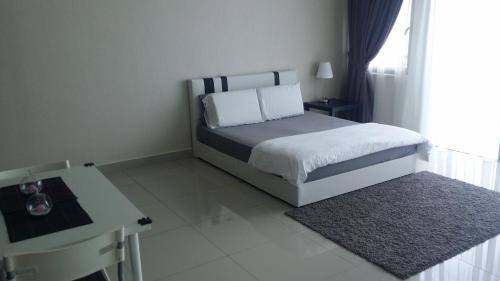 a bedroom with a bed and a table and a desk at Tranquil Studio @ Trefoil Setia Alam in Shah Alam
