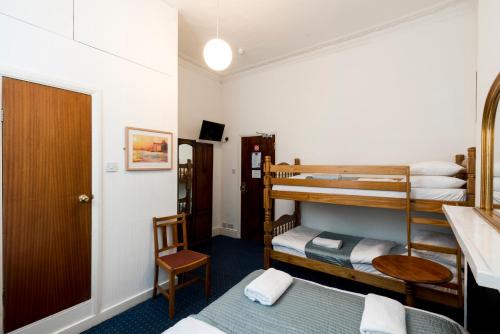 a room with two bunk beds and a bathroom at St Athans Hotel in London