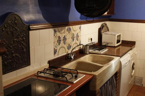 a kitchen with a sink and a microwave at Casa Rural Andrea in Horche