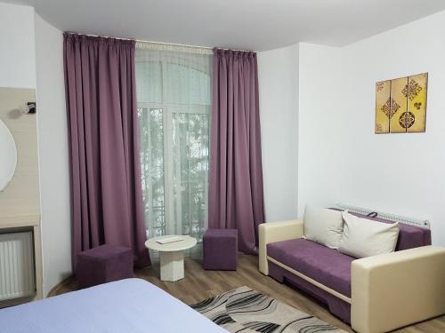 1 dormitorio con sofá púrpura y ventana en Lorena Apart Old Town, en Bucarest