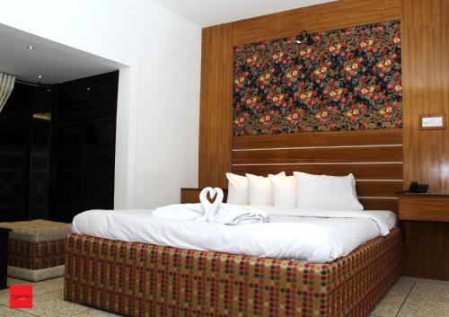 a bed in a hotel room with a picture on the wall at Nagar Valley Hotel Ltd. in Dhaka