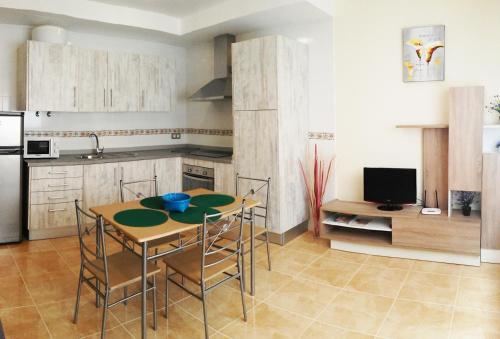 a kitchen with a table and chairs and a television at Apartamento fuerte 1 in Puerto del Rosario