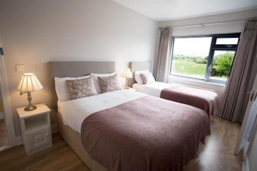 two beds in a bedroom with a window at Island View House in Castletownbere